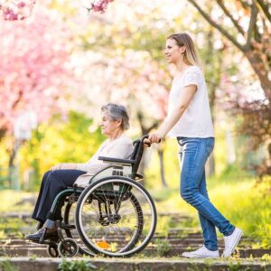 Caregiving and working family going for walk and pushing wheel chair - Family Tree Cares